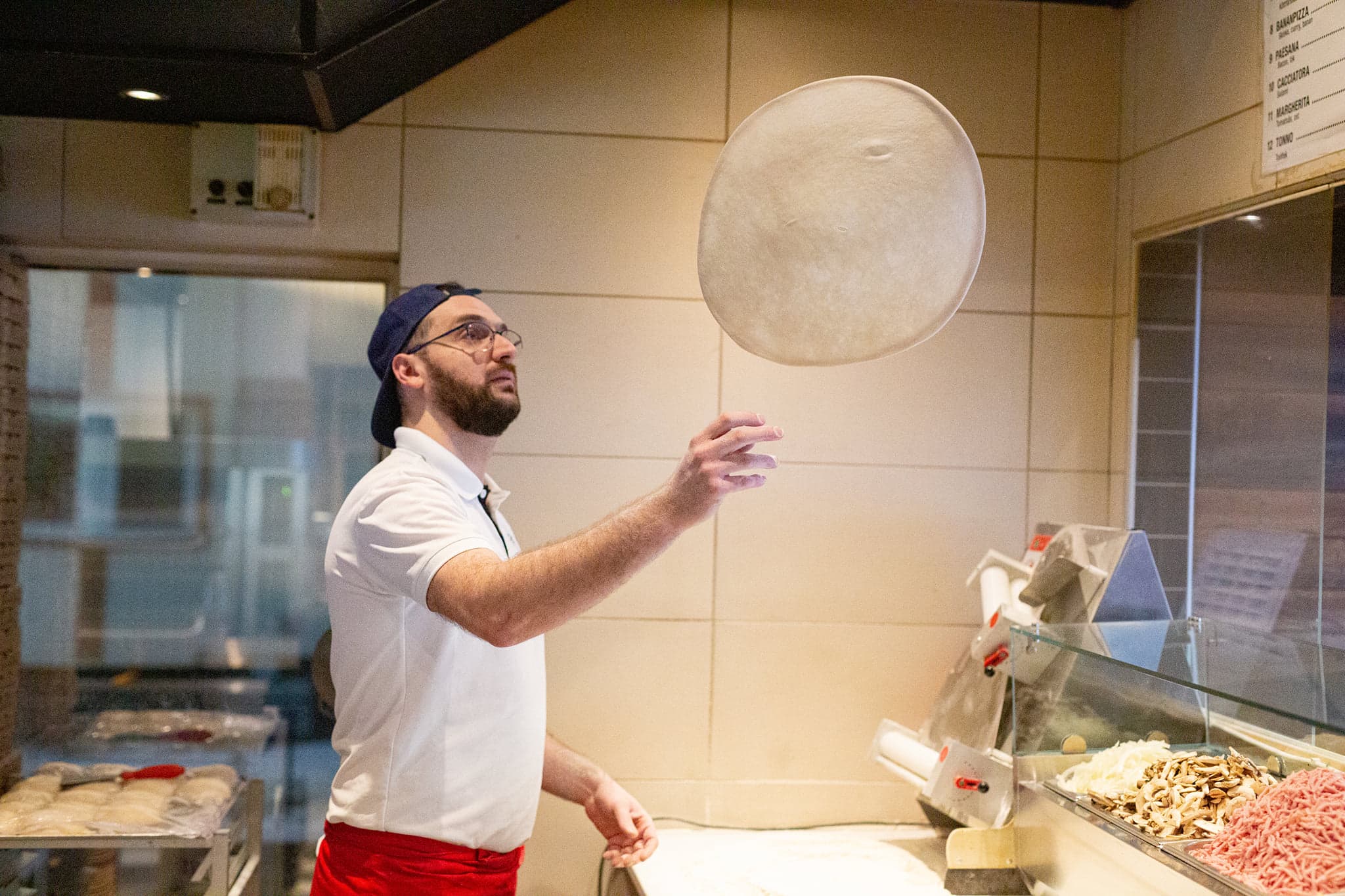 Pizzabagare som virvlar pizzadeg i luften på Pizzeria Rimini i Motala
